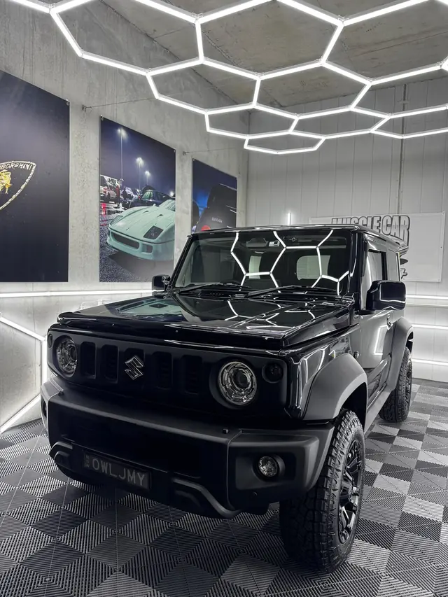 Black Suzuki Jimny front-on in the studio